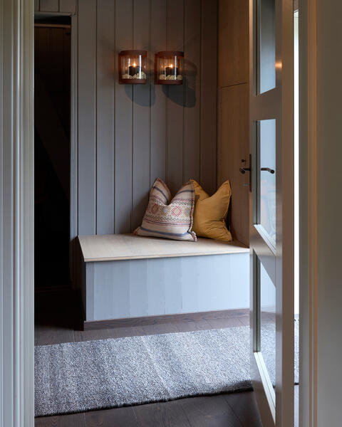 Koselig sittekrok i gangen med nydelige pynteputer som er fylt med innleggsputer som vi har produsert her på Mysen.  Putene inneholder akkurat passe fjær slik at de ikke bare ser lekre ut, men også gir god støtte i ryggen. 